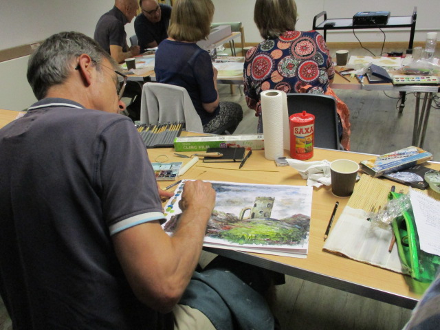 a man painting a picture of a castle